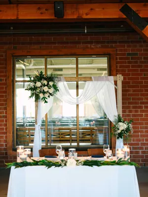 Sweetheart Table Setup with Arch and Brick Background