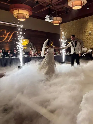 Bride and groom dancing on a cloud floor with sparklers